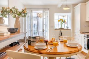 a kitchen with a wooden table with glasses of orange juice at 2 Bed in Baslow oc-h32721 in Baslow