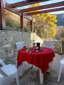 a table with a red table cloth on a patio at La maison du meunier in Olette +9 photos
