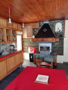 a kitchen with a fireplace and a red table at La maison du meunier in Olette