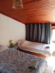 a bedroom with two beds and a black curtain at La maison du meunier in Olette