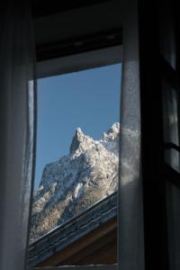 a view of a mountain through a window at Karls Mittenwald - Design Apartments mit Alpenblick & Tagesbar im Herzen von Mittenwald in Mittenwald