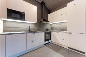 a white kitchen with white cabinets and appliances at Villa Vaellus in Ruka +10 photos