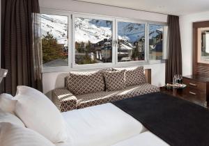a living room with a couch and a large window at Meliá Sol y Nieve in Sierra Nevada