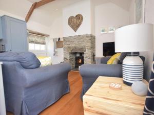 a living room with two blue couches and a fireplace at 2 Bed in Wadebridge oc-82682 in Little Petherick
