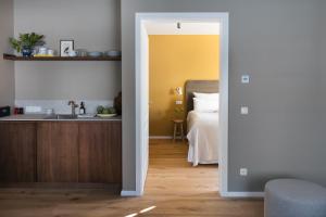 a kitchen and a bedroom with a sink and a bed at Karls Mittenwald - Design Apartments mit Alpenblick & Tagesbar im Herzen von Mittenwald in Mittenwald