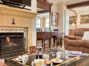 a living room with a fireplace and a piano at 5 Bed in Choseley oc-kt086 in Titchwell