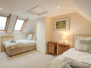 a bedroom with two beds and a dresser and windows at 5 Bed in Choseley oc-kt086 in Titchwell