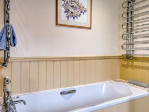 a bath tub in a bathroom with a picture on the wall at 5 Bed in Choseley oc-kt086 in Titchwell +21 photos