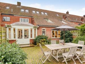 a patio with a table and chairs and an umbrella at 5 Bed in Choseley oc-kt086 in Titchwell