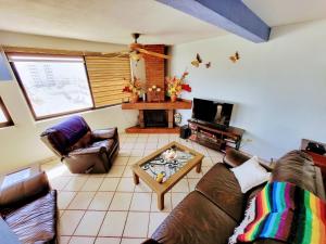 a living room with two couches and a tv at Penthouse Water View in Puerto Peñasco