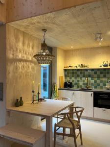 a kitchen with a table and chairs and a chandelier at de KruidenPoort in Woudrichem