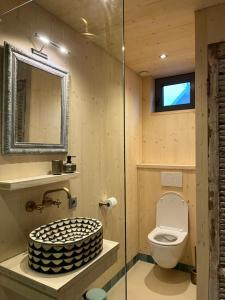 a bathroom with a toilet and a glass shower at de KruidenPoort in Woudrichem +18 photos