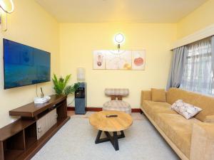 a living room with a couch and a table at Cosy 1 BR with Swimming Pool & Garden & 25 Mins to Airport - C04 in Mombasa