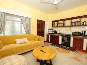 a living room with a couch and a table at Cosy 1 BR with Swimming Pool & Garden & 25 Mins to Airport - C04 in Mombasa