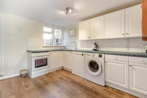 a kitchen with white cabinets and a washer and dryer at 2 Bed in Ashley oc-c32637 in Ashley