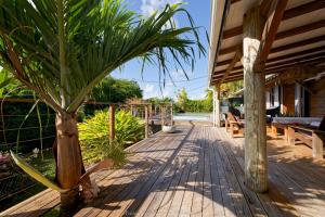 a wooden porch with a palm tree on it at Makiese Resort in Saint-François