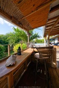 a wooden bar with a table and a chair on a deck at Makiese Resort in Saint-François