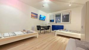 a living room with two beds and a table at Wohnreich Blaustein Mitte - Wohnung 3B - 2-Zimmerwohnung in Blaustein +11 photos
