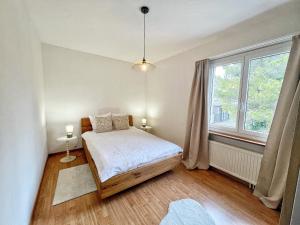 a bedroom with a bed and a large window at Horizon Lac - wifi - parking in Morges