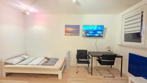 a bedroom with a bed and a desk and a table at Wohnreich Blaustein Mitte - Wohnung 3B - 2-Zimmerwohnung in Blaustein