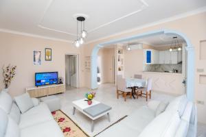 a living room with a white couch and a table at Villa Evelyn Free Parking in Vlorë