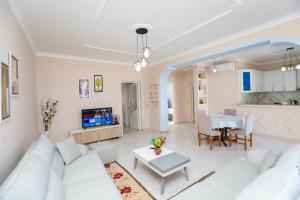 a living room with a white couch and a table at Villa Evelyn Free Parking in Vlorë
