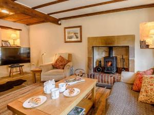 a living room with a fireplace and a table at 2 Bed in Matlock oc-pk885 in Winster