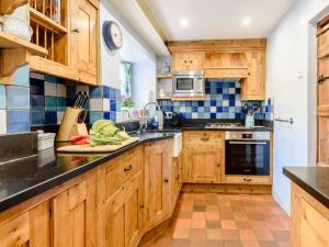 a kitchen with wooden cabinets and a stove top oven at 2 Bed in Matlock oc-pk885 in Winster +16 photos