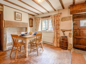 a dining room with a table and chairs and a fireplace at 2 Bed in Matlock oc-pk885 in Winster