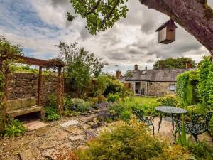 a garden with a table and chairs and a building at 2 Bed in Matlock oc-pk885 in Winster