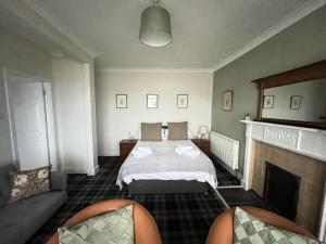 a bedroom with a bed and a fireplace at The Rhu Inn in Rhu