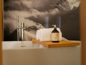 ein Badezimmer mit einer Flasche Seife auf einem Waschbecken in der Unterkunft Eiger Mountain & Soul Resort in Grindelwald + 84 Fotos