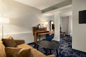 a living room with a couch and a desk in a hotel room at Fairfield Inn & Suites Savannah I-95 South in Savannah