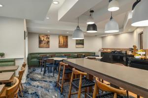 a restaurant with tables and chairs and a bar at Fairfield Inn & Suites Savannah I-95 South in Savannah