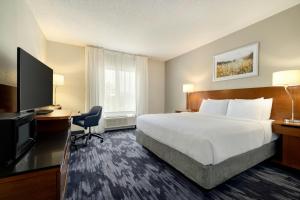 a hotel room with a bed and a flat screen tv at Fairfield Inn & Suites Savannah I-95 South in Savannah +21 photos