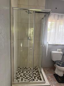 a shower stall in a bathroom with a toilet at La Bushka Guesthouse in Bela-Bela +22 photos