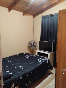 a bedroom with a bed and a television at Hospedaje Cabaña Completa in Rivera