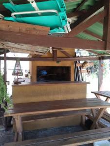 a picnic table with a fireplace under a roof at Hospedaje Cabaña Completa in Rivera