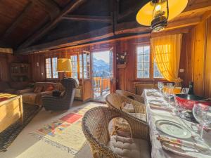 a dining room with a table and chairs with a view at Chalet Le Zirizui - Authentique refuge alpin avec vue imprenable in Liddes