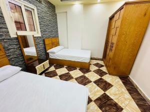 a bedroom with two beds and a checkered floor at Apartment 18 Maspero in Alexandria