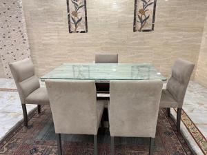 a glass dining table with chairs in a room at Apartment 18 Maspero in Alexandria