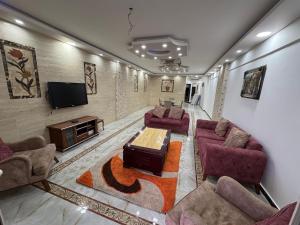 a living room with couches and a flat screen tv at Apartment 18 Maspero in Alexandria