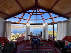 a room with a large window with a view of the water at Titicaca Lodge Flotante in Puno