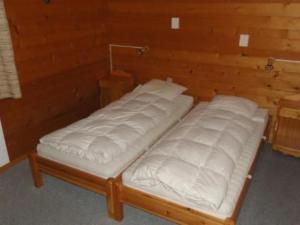 two beds in a room with white sheets at Apartment Nicole 1 by Interhome in Blatten bei Naters