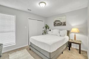 a bedroom with a white bed and a window at Uptown Serenity in North Little Rock