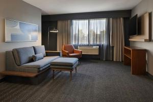 a hotel room with a couch and a chair at Courtyard by Marriott Sacramento Midtown in Sacramento