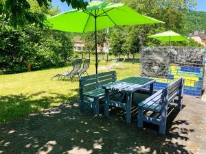 a table and two benches with a green umbrella at Apartment Perle-Lollipop by Interhome in Bullay