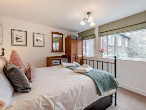 a bedroom with a bed with pillows and a window at 2 Bed in Ambleside oc-sz500 in Grasmere