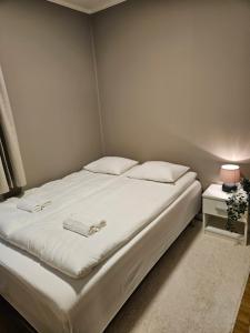 a bedroom with a large bed with white sheets and pillows at Cozy House in Tromsø - Near City Center, Ideal for Families & Groups in Tromsø