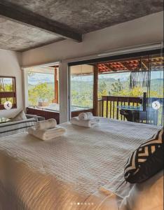 a bedroom with a large bed with two towels on it at Pousada Caminho Das Cachoeiras in Sao Jorge +32 photos